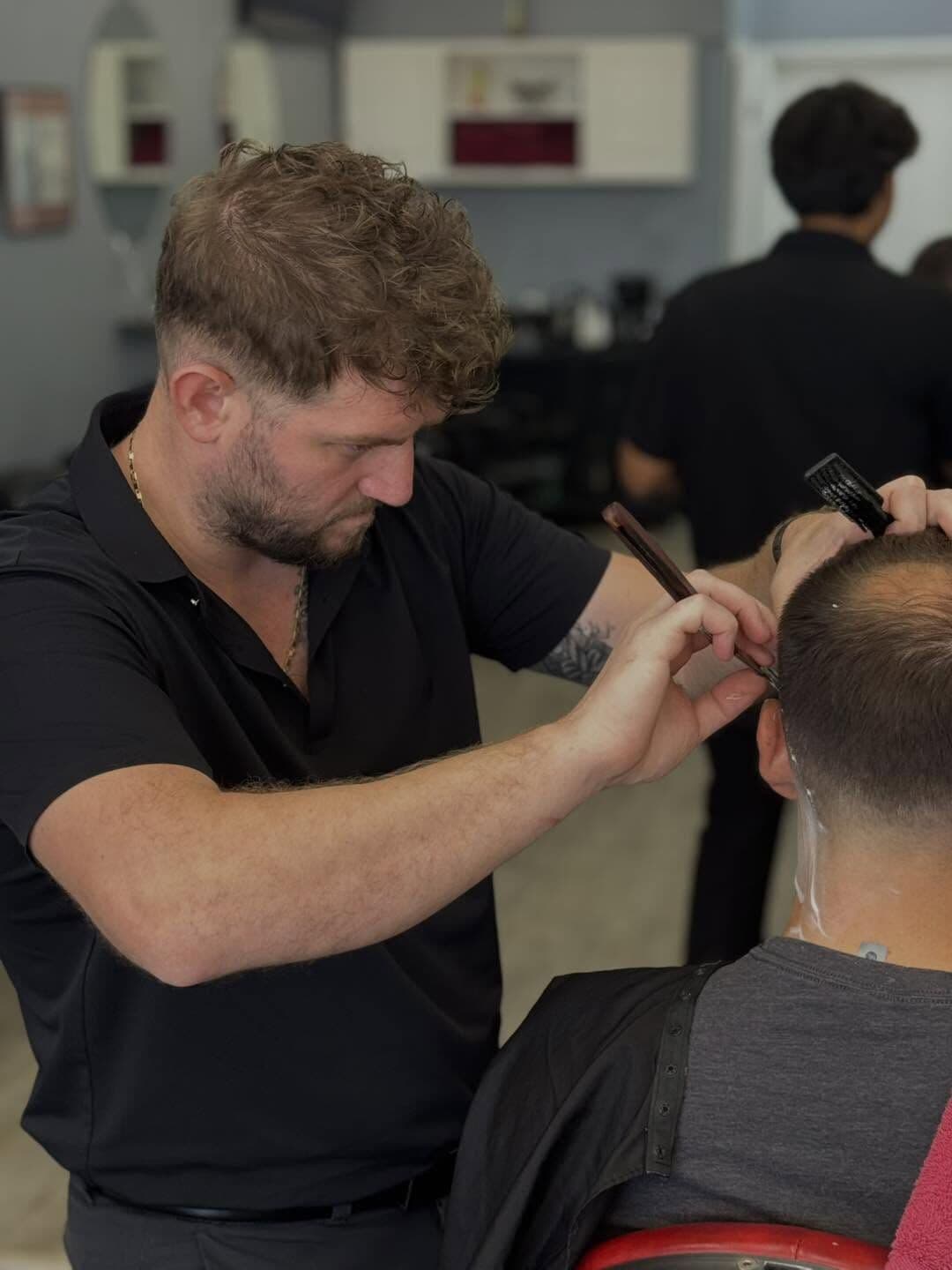 Andy Peto detailing the back of a client's haircut with a straight razor