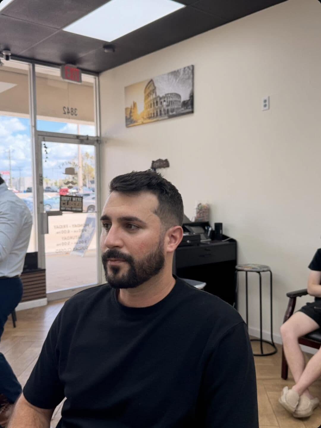 A client with a short textured cut and a full, shaped beard