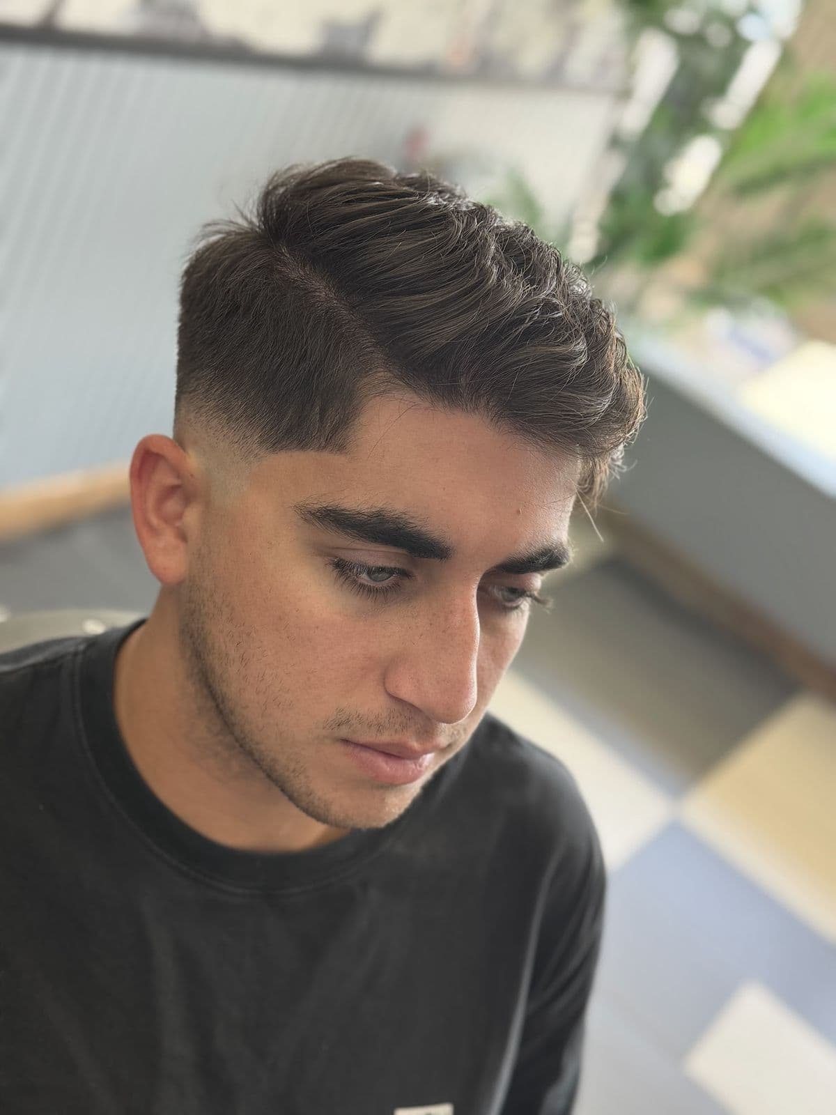 A low fade with a textured crop on top, seen from the side