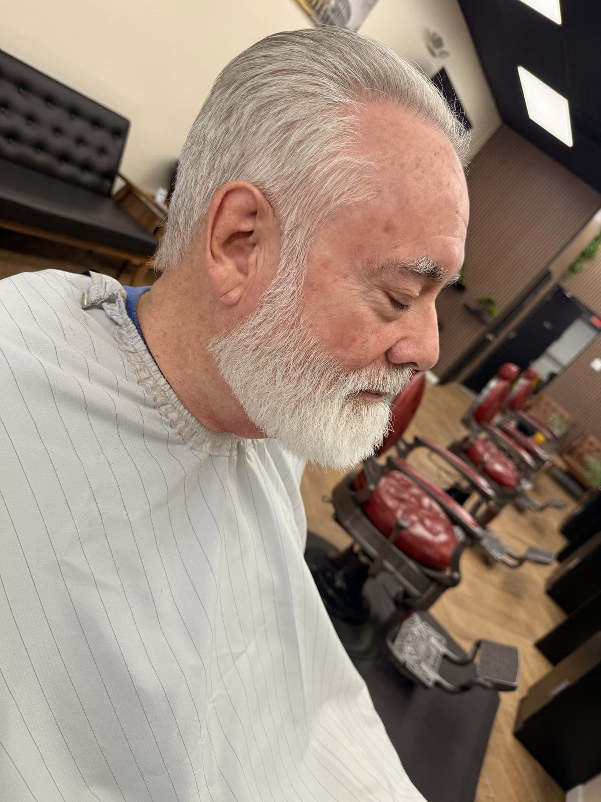 A client with a neatly trimmed white beard and swept-back hair