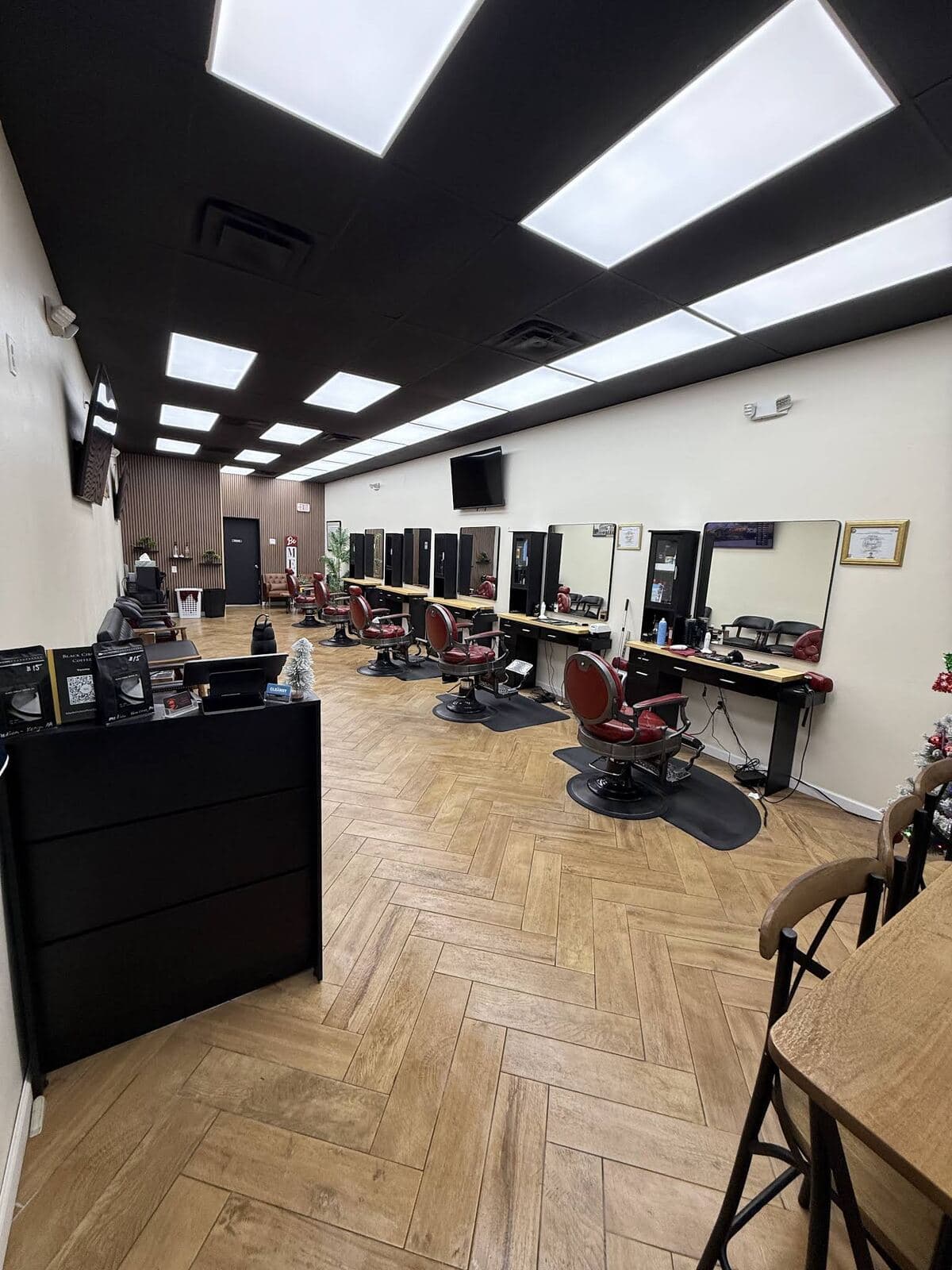 The full length of the shop: stations, red chairs and a herringbone floor