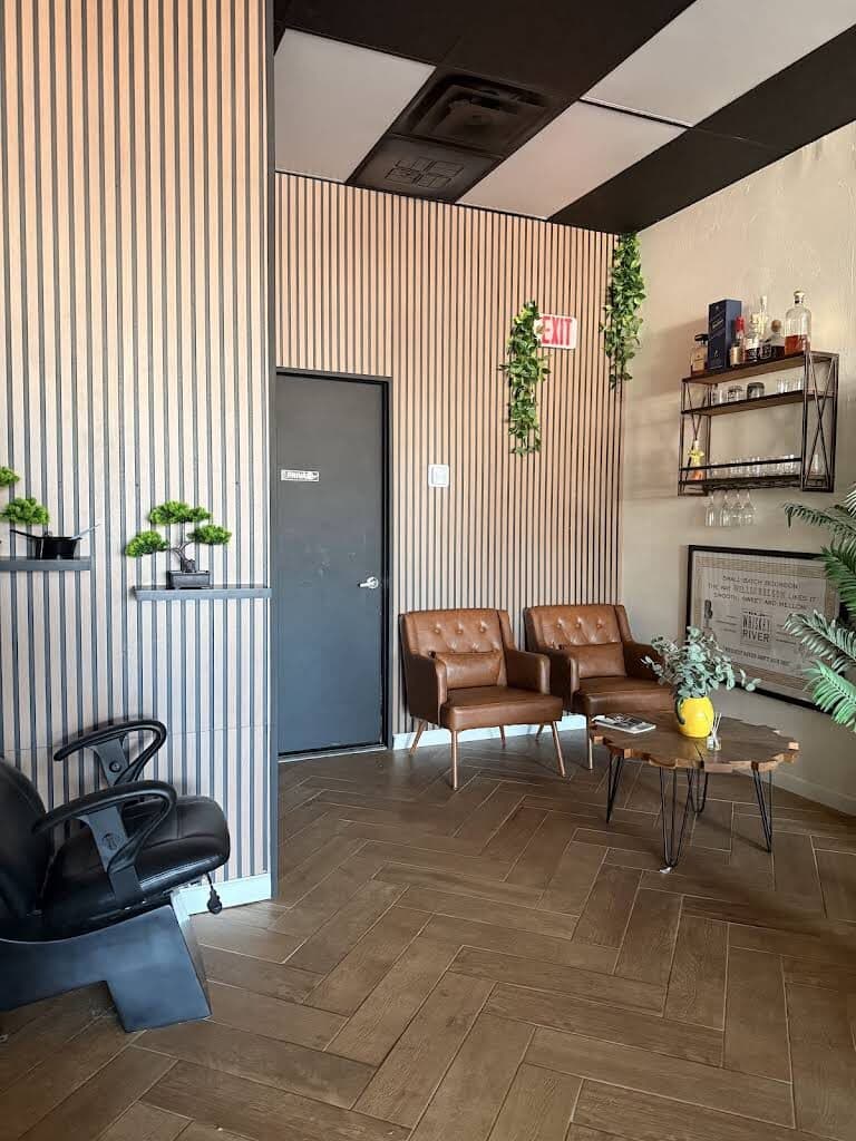 Leather chairs and plants against the wood-slat wall at the back of the shop