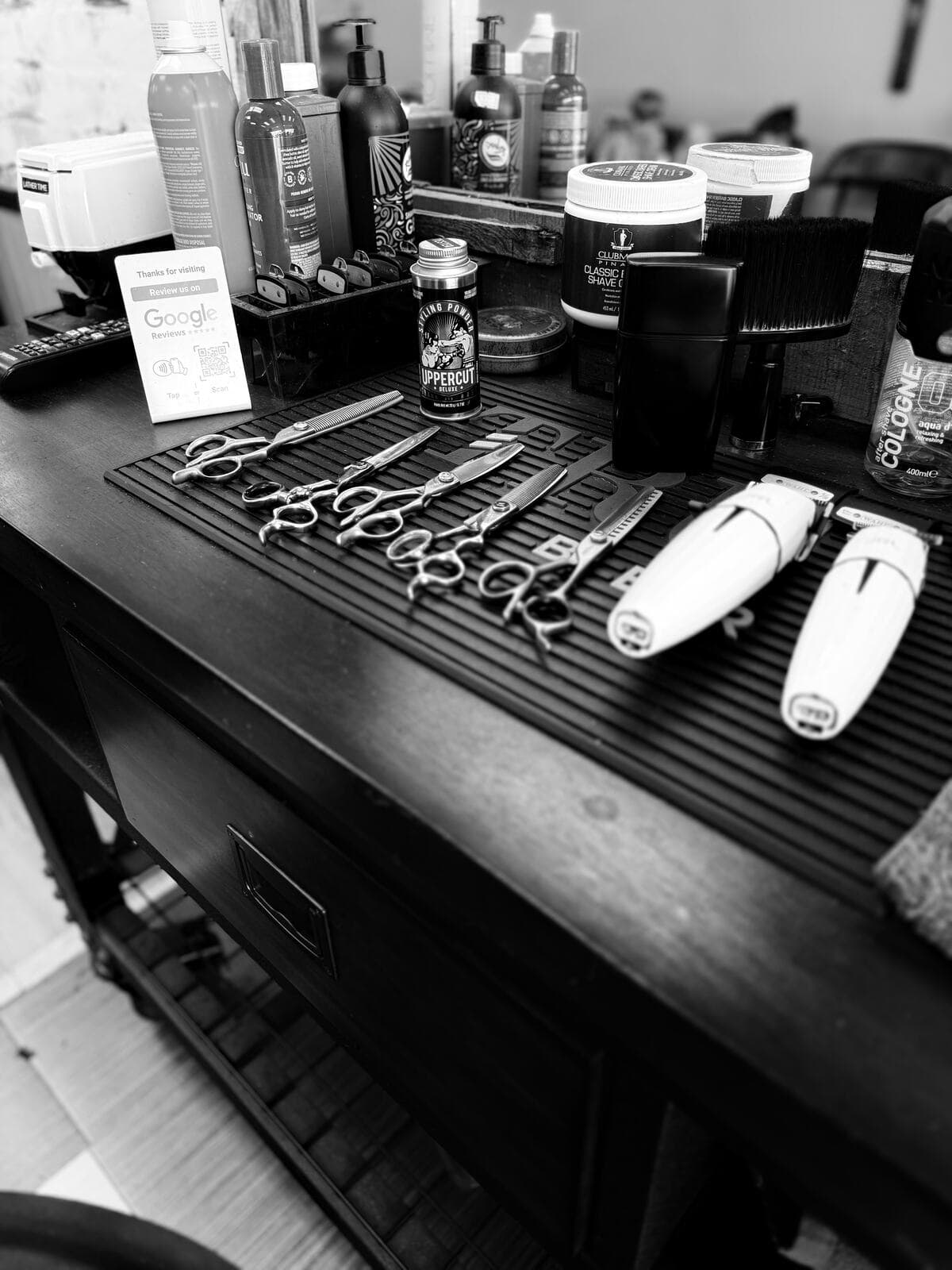 Clippers, scissors and products laid out at a barber station